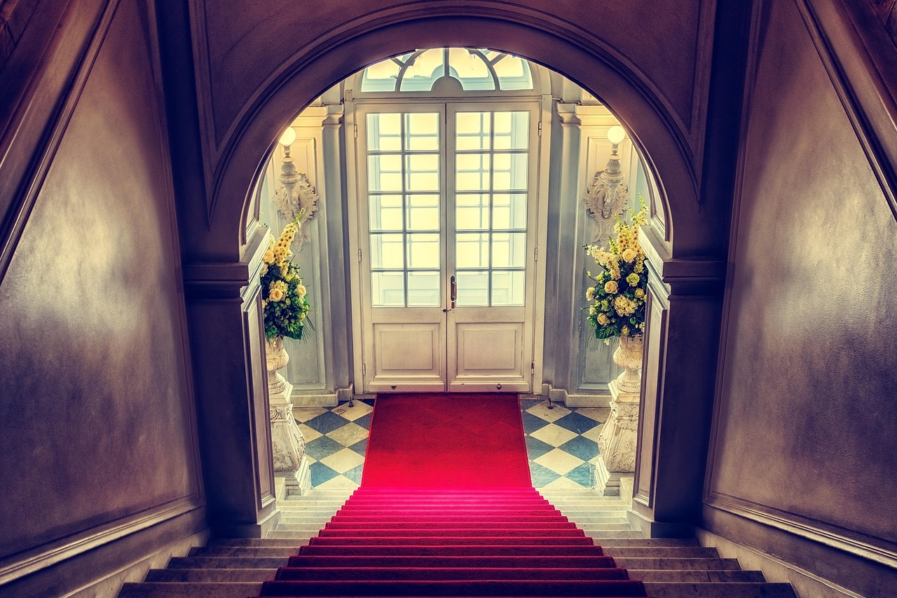 Red carpet staircase in opulent foyer